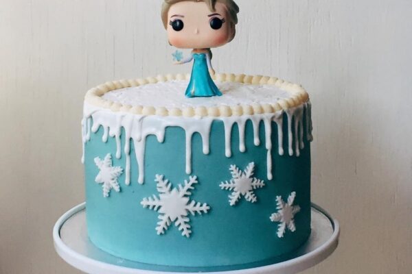 Frozen elsa cake with white chocolate drizzle and fondant snowflake cutouts
